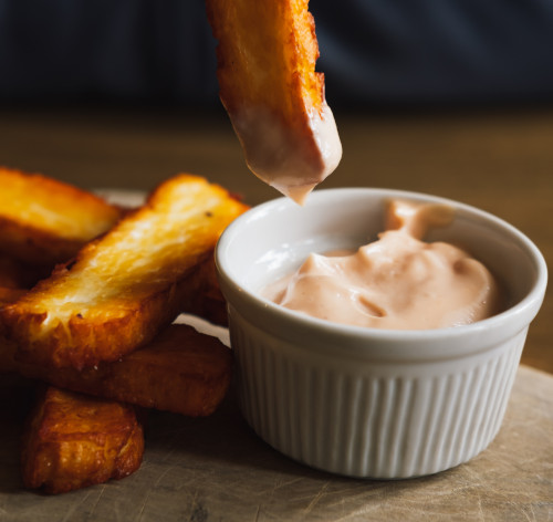 a chip being dipped into mayonnaise