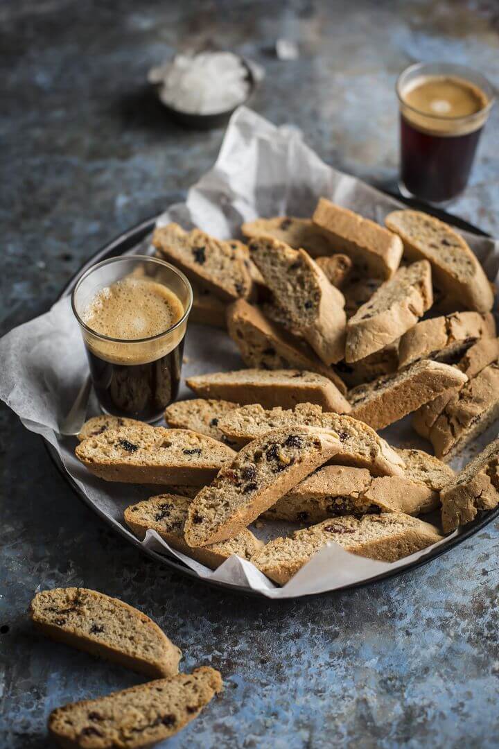 A tray of raisin rusks with coffee next to it